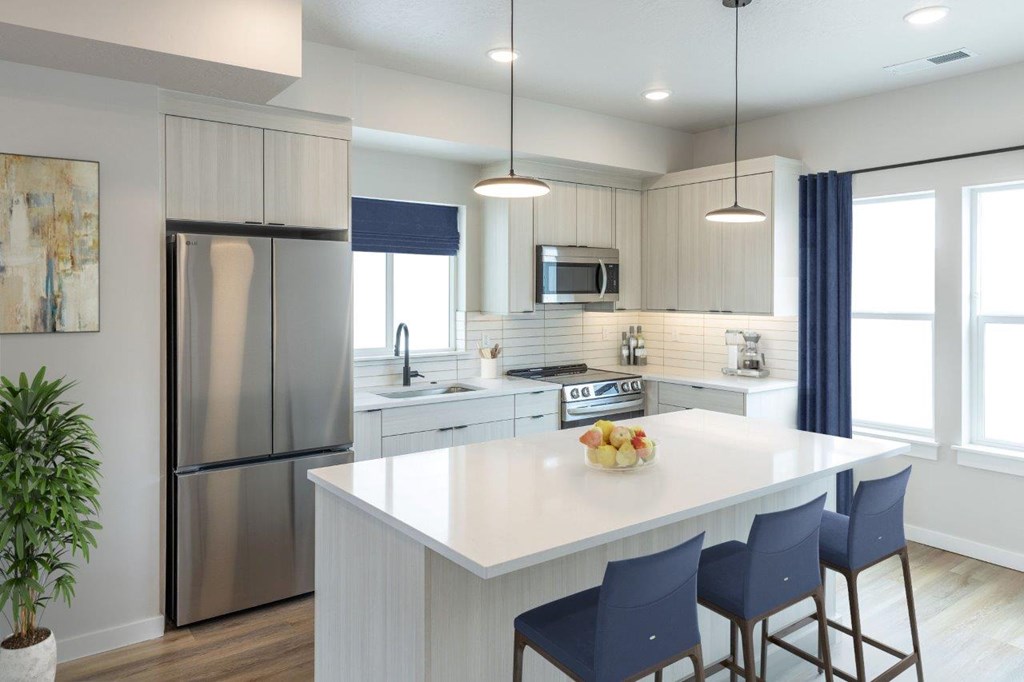 A modern kitchen with a large island and stainless steel appliances.