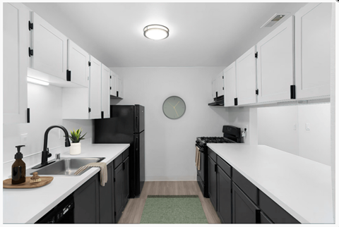 A modern kitchen with black cabinets and white countertops.