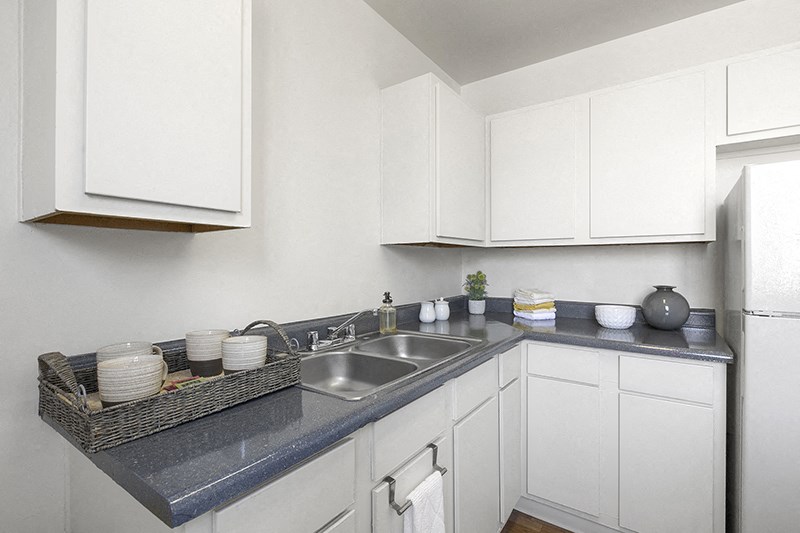 a kitchen with white cabinets and a blue counter top