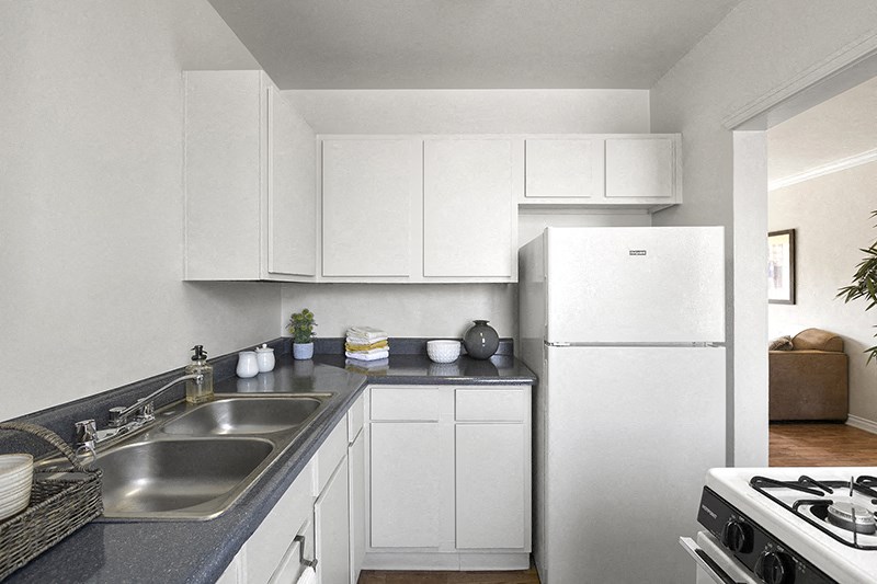 a kitchen with white cabinets and a stainless steel sink