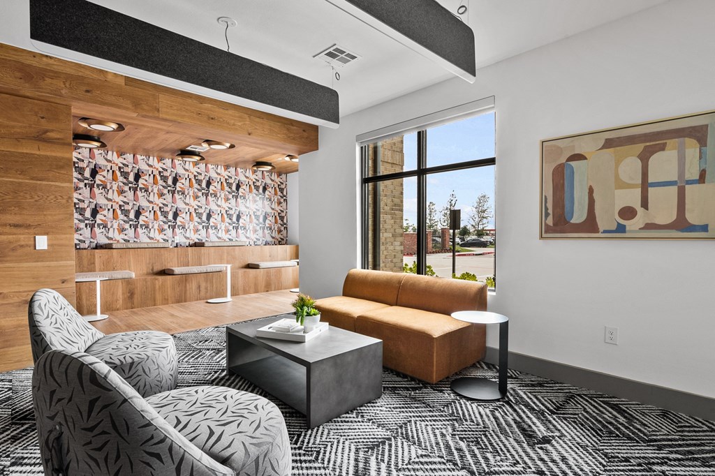 a living room with a brown couch and a black and white rug