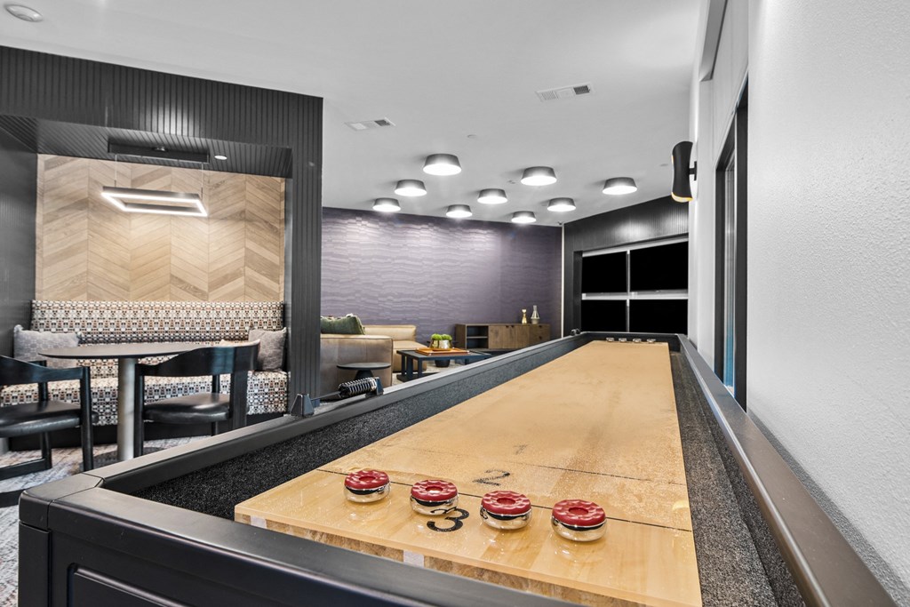 a long wooden ping pong table in a room with a large mirror
