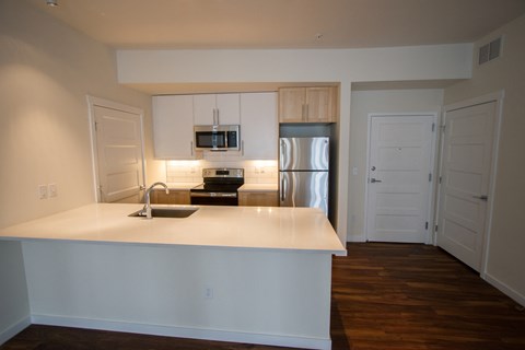 a kitchen with a white counter top and a refrigerator