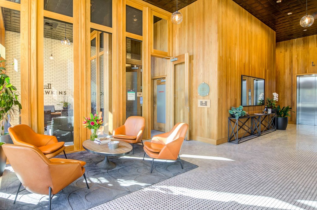 a lobby with orange chairs and a coffee table