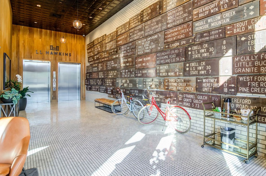 a room with a wall of wooden signs on the wall and two bikes in front of it