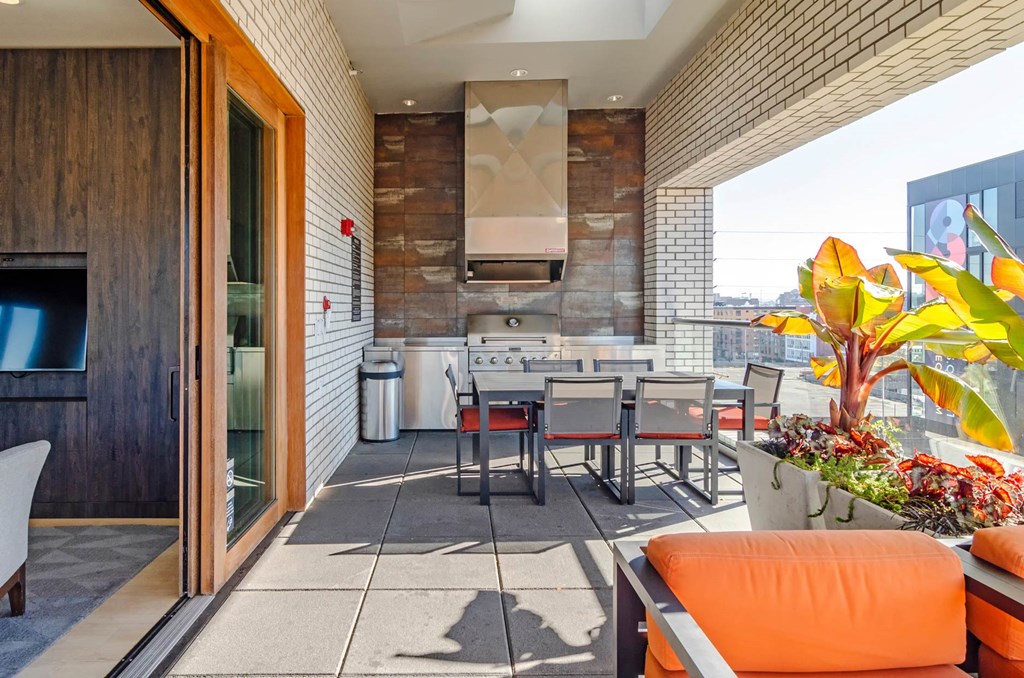 a patio with a table and chairs and a kitchen in the background