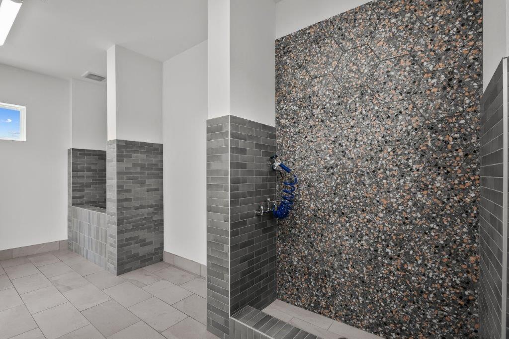 a bathroom with a shower with a blue hose in it