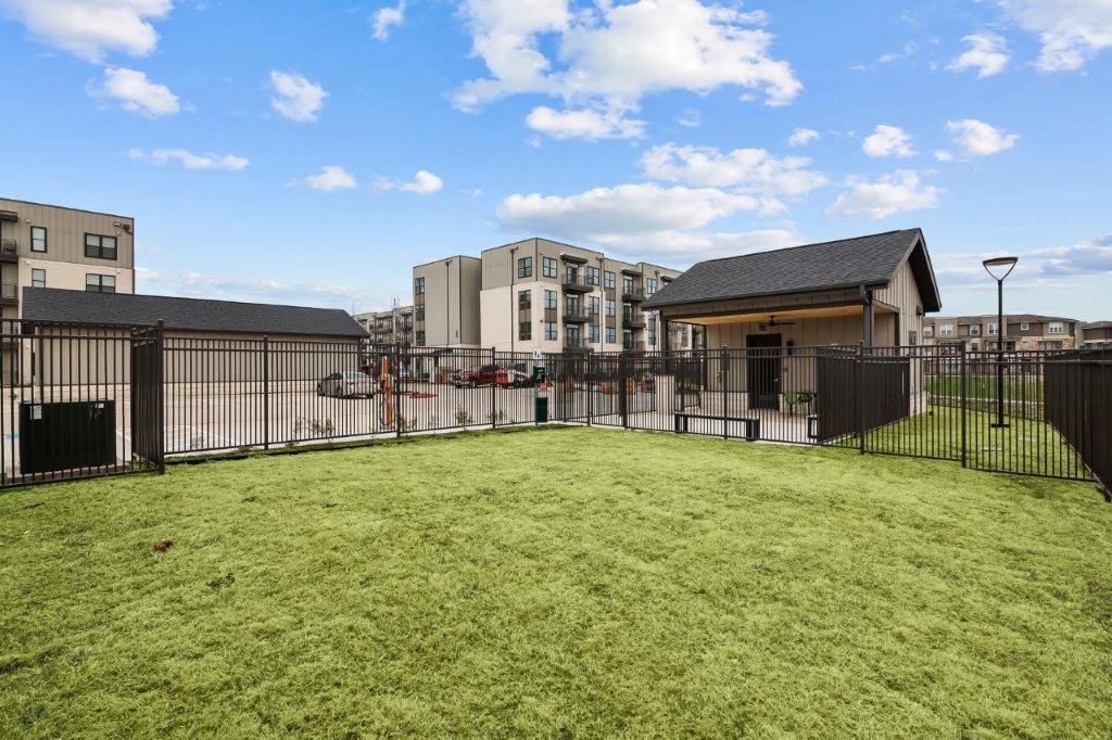 a fenced in yard with apartments in the background