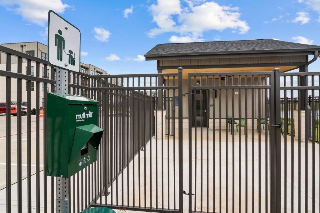 a metal fence with a green parking lot