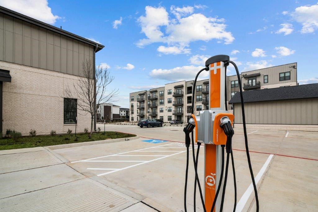 an orange gas pump in a parking lot next to a building