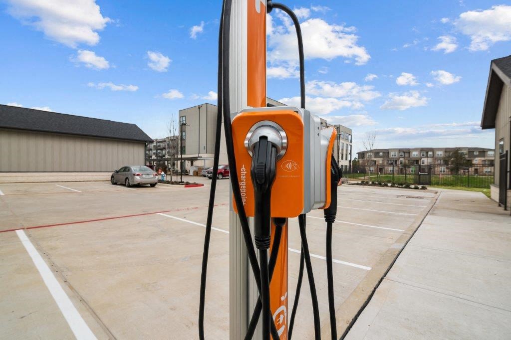 an orange electric charger plugged into a parking lot