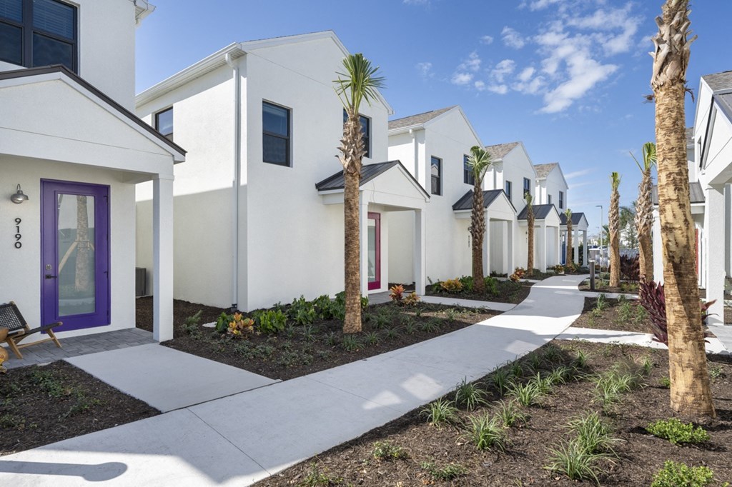 a row of white houses with palm trees