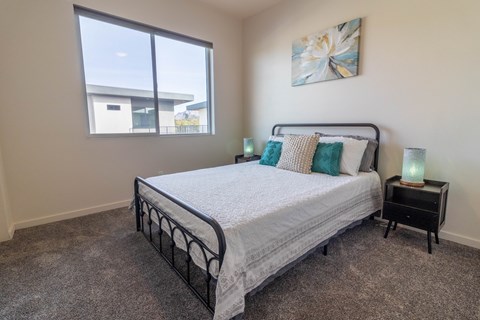 A bedroom with a large bed and a window overlooking a building.