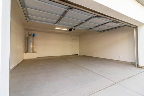 A spacious garage with a white ceiling and a closed door.