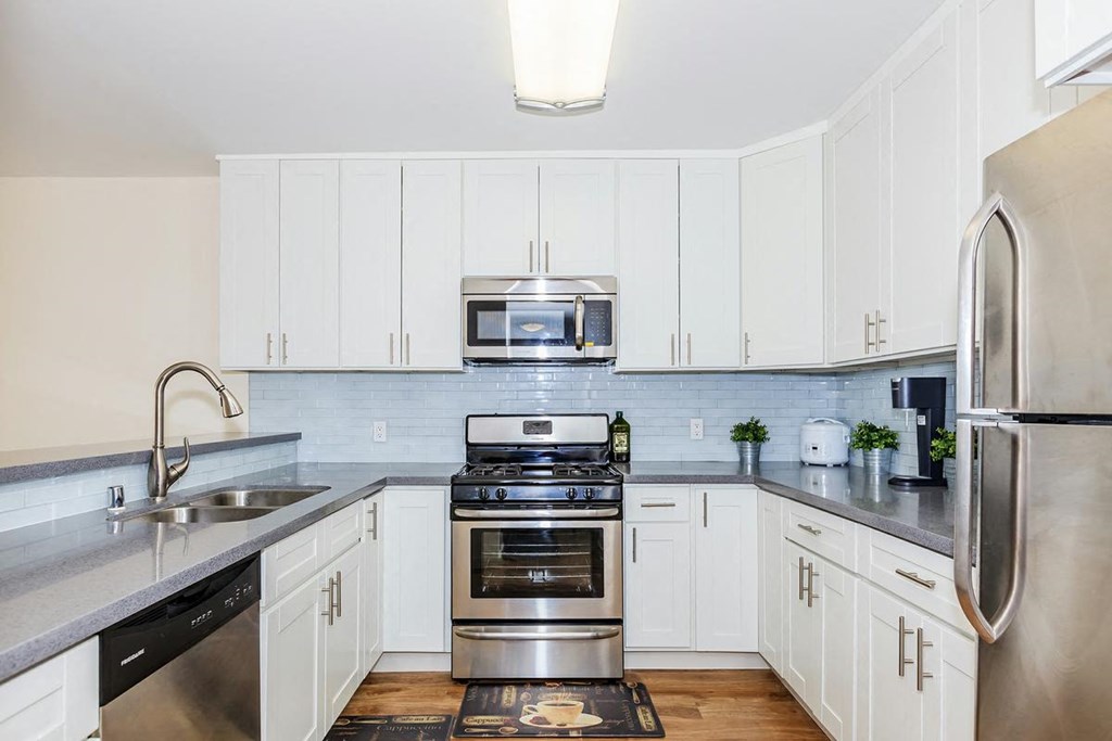 a kitchen with stainless steel appliances and white cabinets