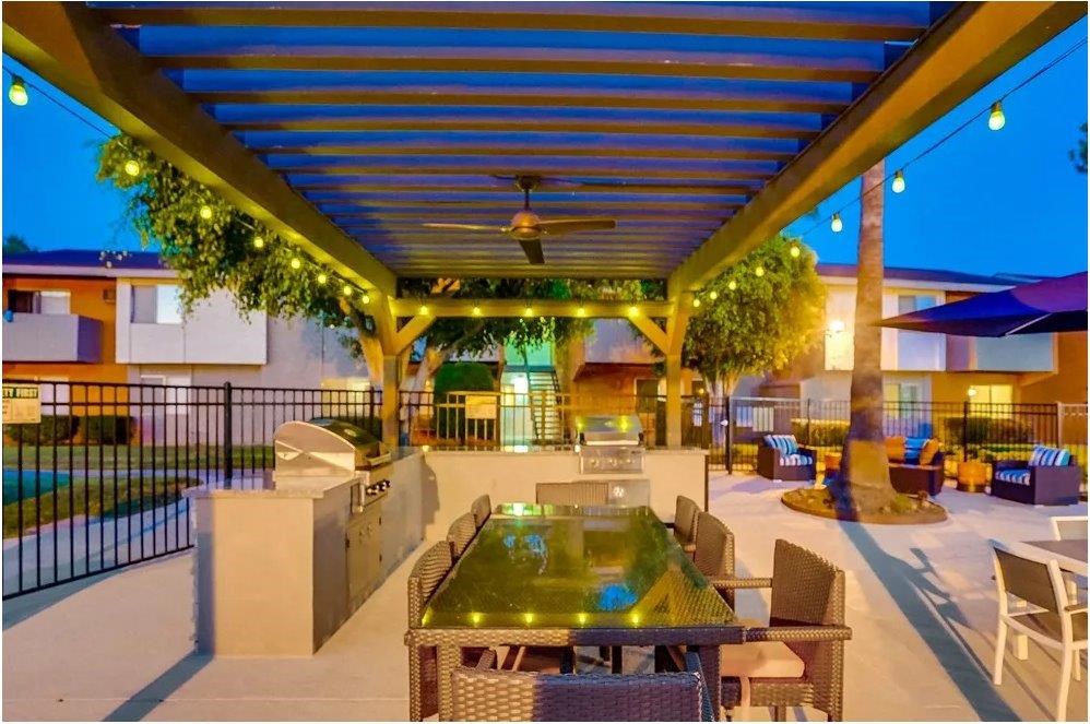 A patio with a table and chairs under a roof.