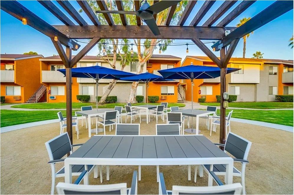 A patio with a table and chairs under a pergola.