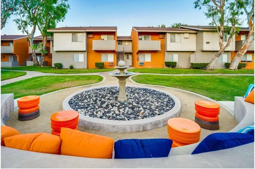 A courtyard with a fountain surrounded by orange and blue seating.