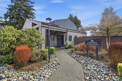 A building with a sign that says "Latitude Welcoming Center" in front of it.