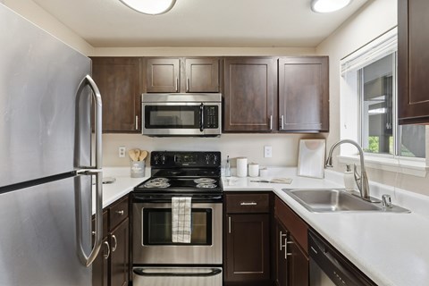 A kitchen with brown cabinets and a black stove top.