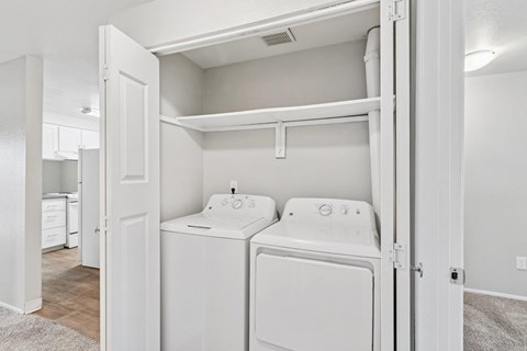 A white washer and dryer are in a small laundry room.