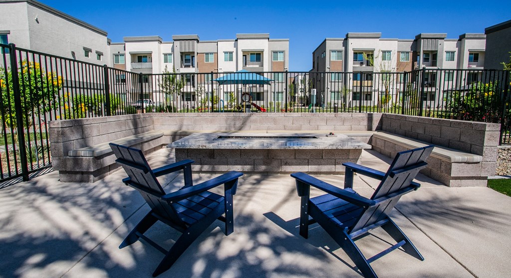 an outdoor patio with chairs and a fire pit