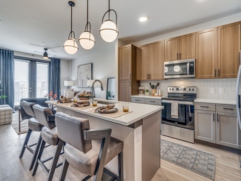 A modern kitchen with wooden cabinets and a white island.