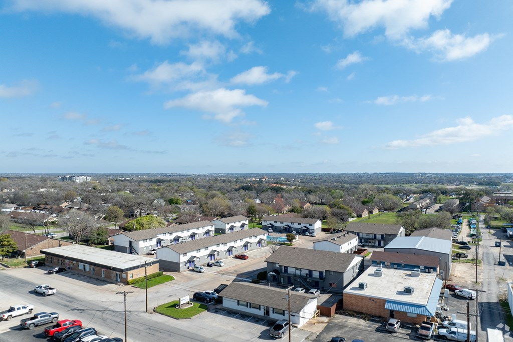 an aerial view of a neighborhood of buildings and cars in a parking lot