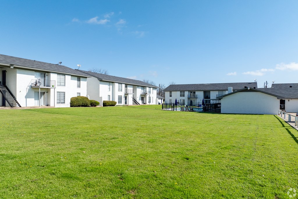 a group of white houses on a green lawn