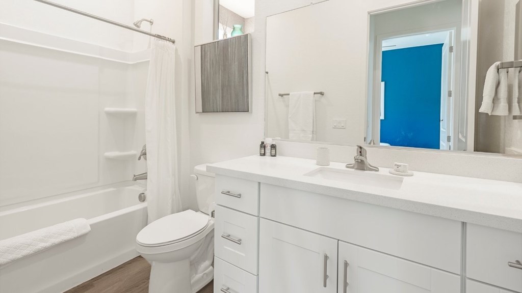 A white bathroom with a toilet, sink, and bathtub.