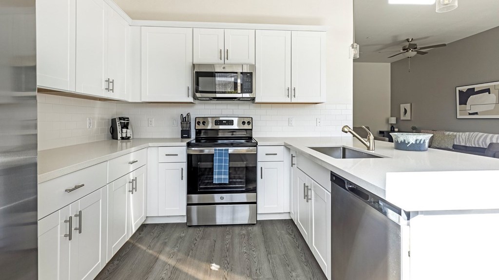 A modern kitchen with white cabinets and stainless steel appliances.