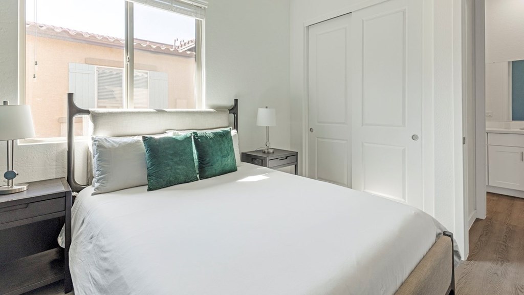 A bedroom with a large bed and a window.