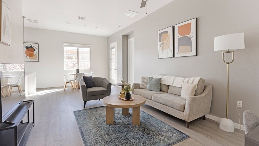 A living room with a grey couch, a coffee table, and a lamp.