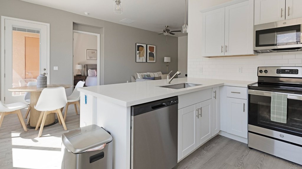 A modern kitchen with white cabinets and stainless steel appliances.