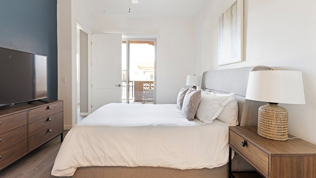 A bedroom with a bed, nightstand, and a television.