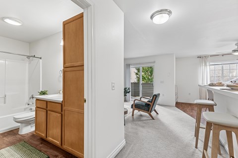 A bathroom with a wooden cabinet and a chair in the living room.