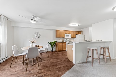 A kitchen with a dining table and chairs.