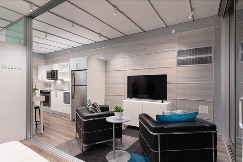 a living room with black leather furniture and a television