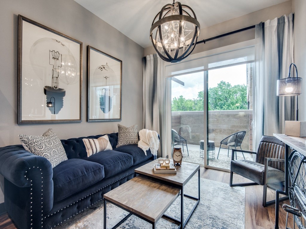 a living room with a blue couch and a coffee table in front of a sliding glass door