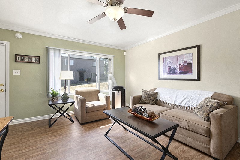 a living room with a ceiling fan and a couch and chair