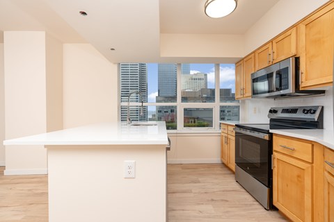A kitchen with wooden cabinets and a white island.