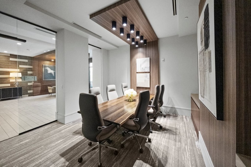 A conference room with a long table and chairs.