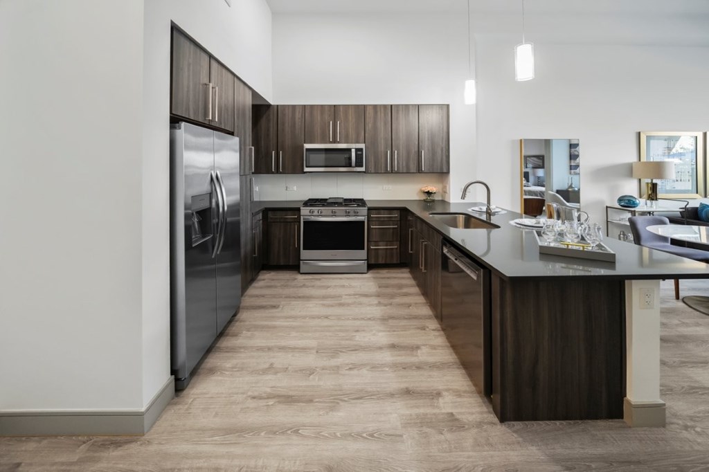 A modern kitchen with dark wood cabinets and a large island.