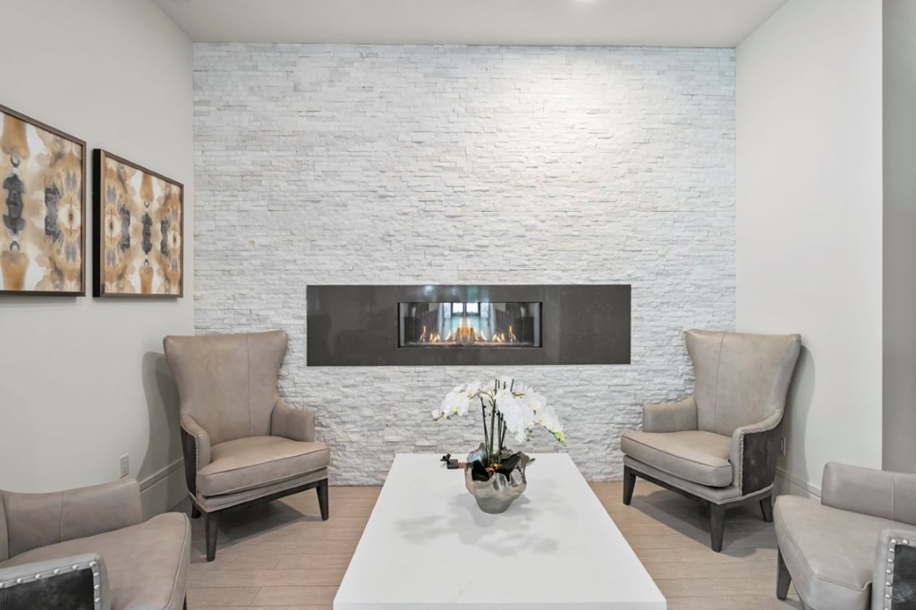 A living room with a fireplace and two chairs.