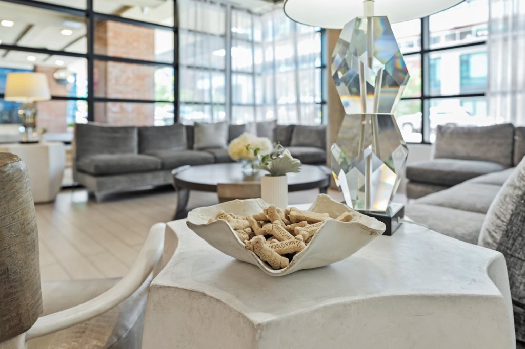 A modern living room with a white coffee table and grey couches.