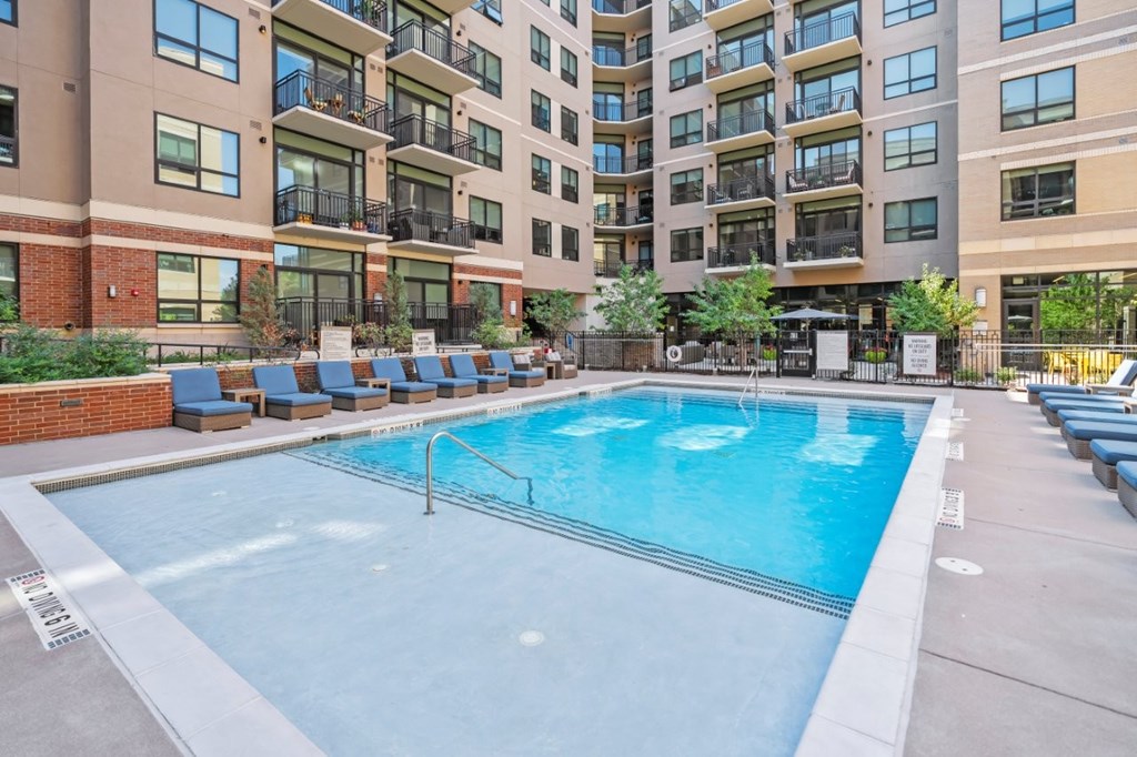 A large swimming pool in front of apartment buildings.