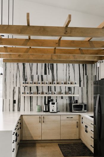 a kitchen with white cabinets and a black refrigerator