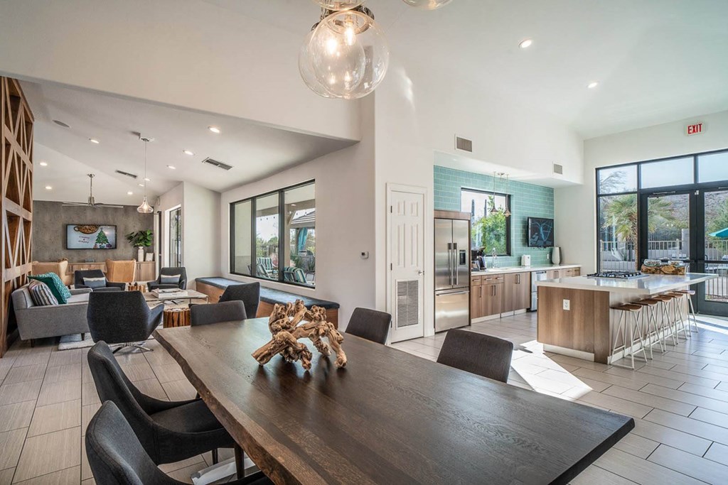 a dining room table with a view of a kitchen and living room in the background