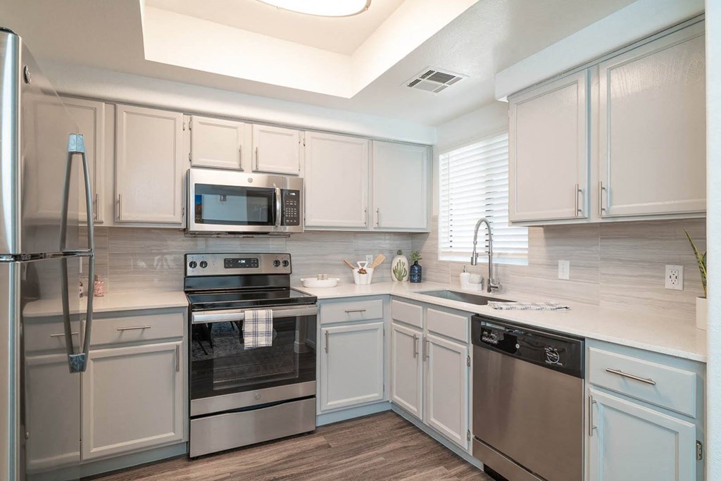 a kitchen with white cabinets and stainless steel appliances