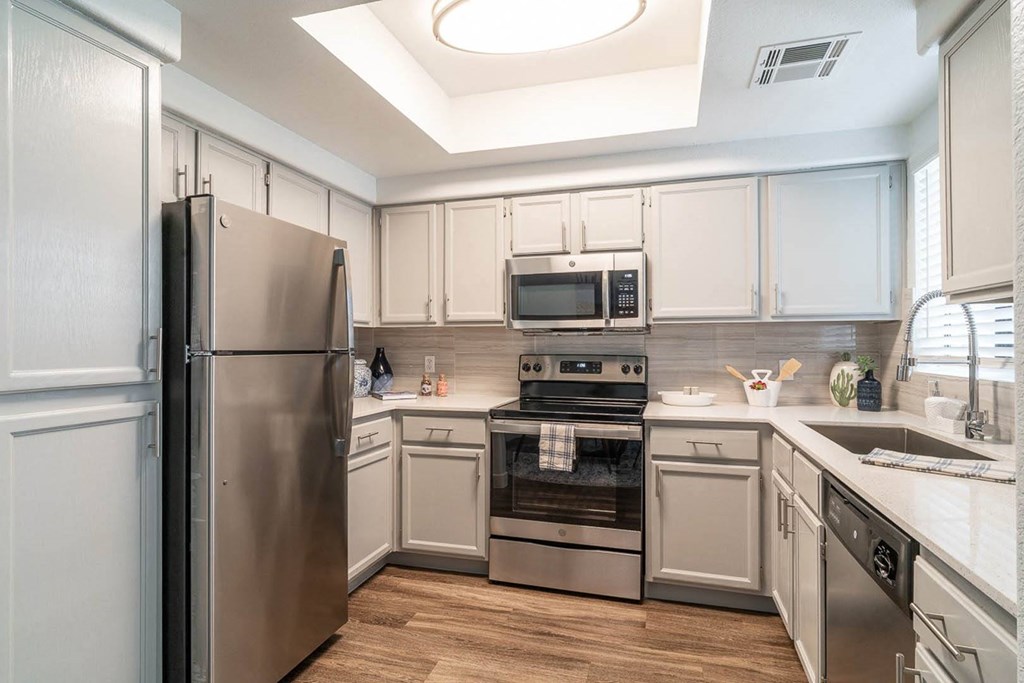 a kitchen with white cabinets and stainless steel appliances